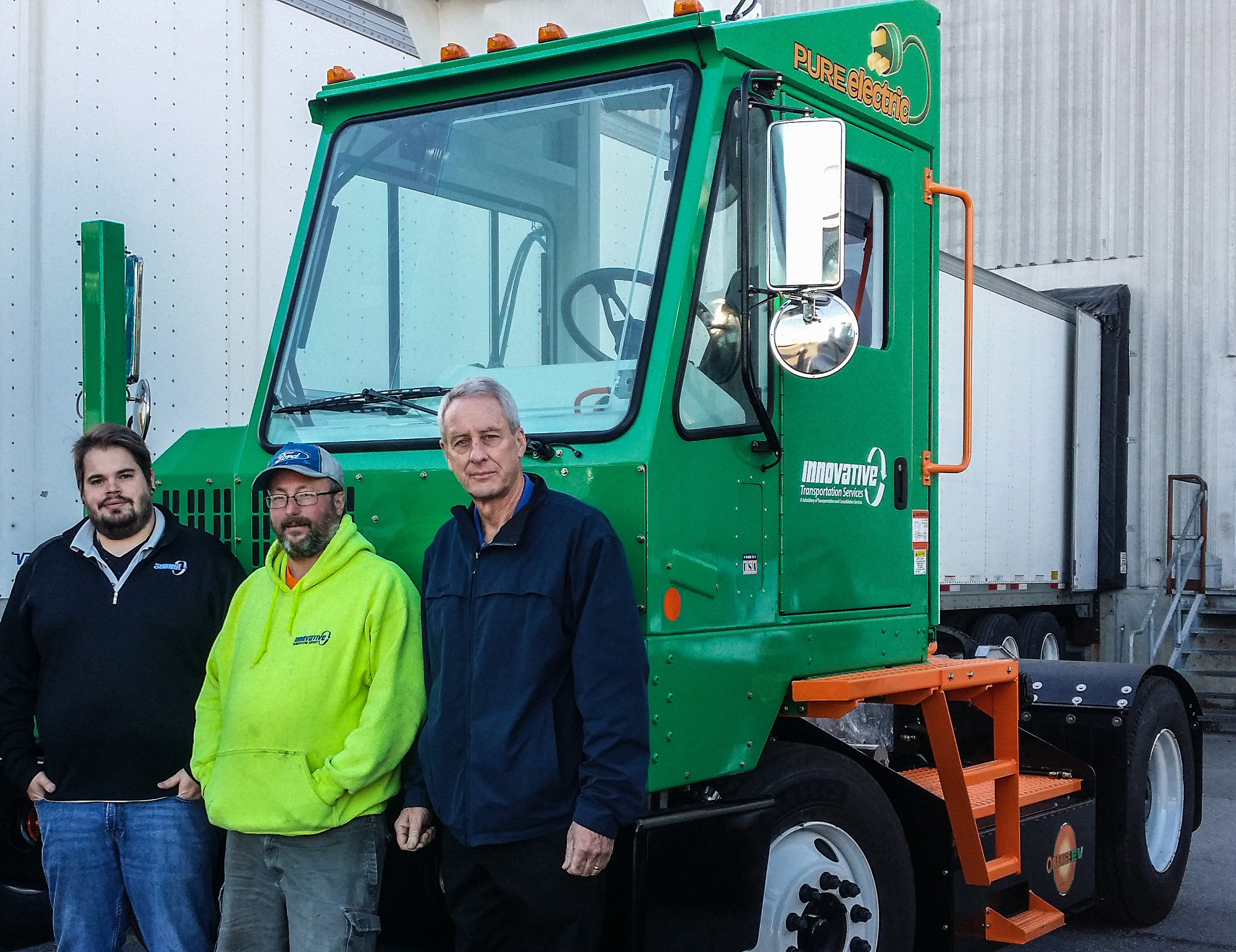 Innovative Transportation Services (ITS) with their new Orange EV T-Series pure-electric terminal truck. From left: James Hotnich, Dispatch Manager; Owen Owens, Driver; and Dave Harper, President of ITS.