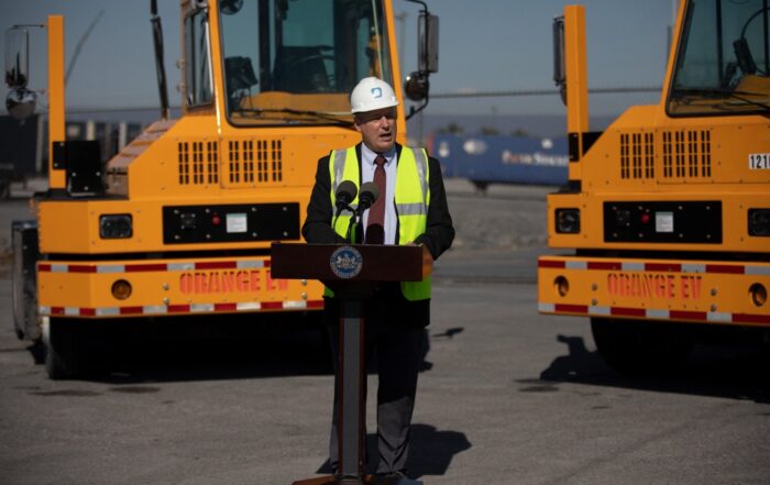 A man with a hazard vest and protective hat with EV trucks