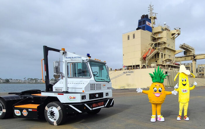 Dole company mascot and Orange EV trucks